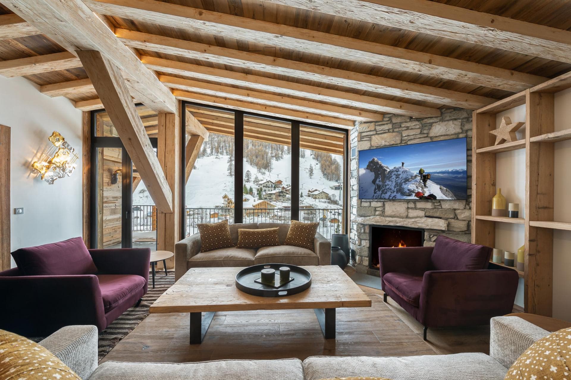 Living area with wood-burning fireplace and floor-to-ceiling ski resort views