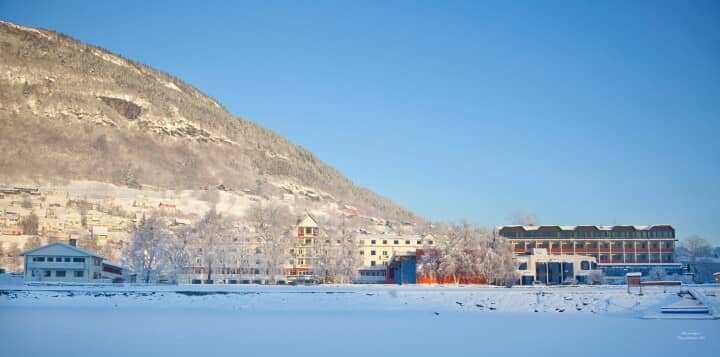 Snow-covered valley view with mountain backdrop and waterfront proximity