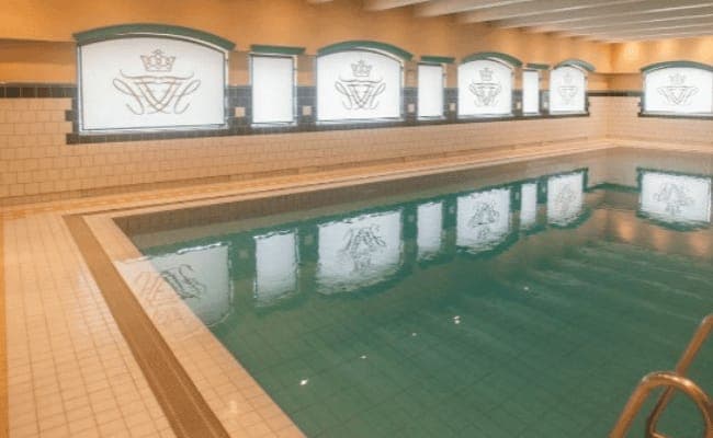 Indoor pool with frosted privacy windows and tiled deck