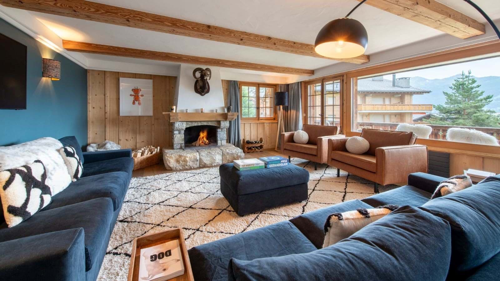 Living area with wood-burning stone fireplace and mountain-view terrace access