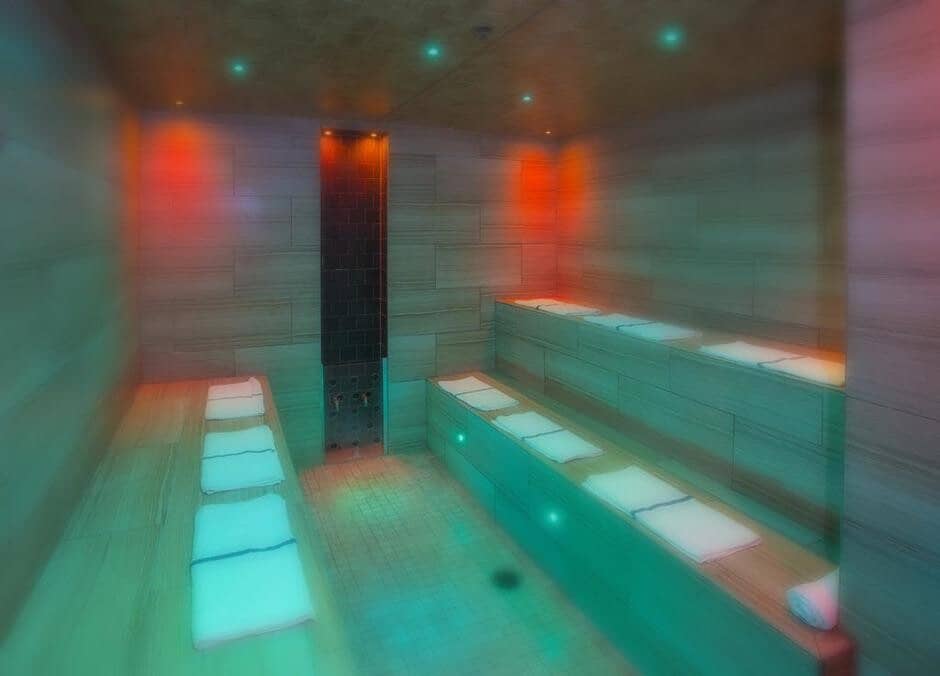 Private steam room with two-tier seating and integrated chromotherapy lighting