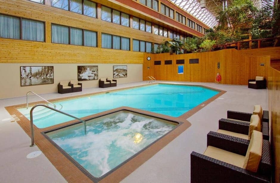 Indoor atrium pool and hot tub with lounge seating