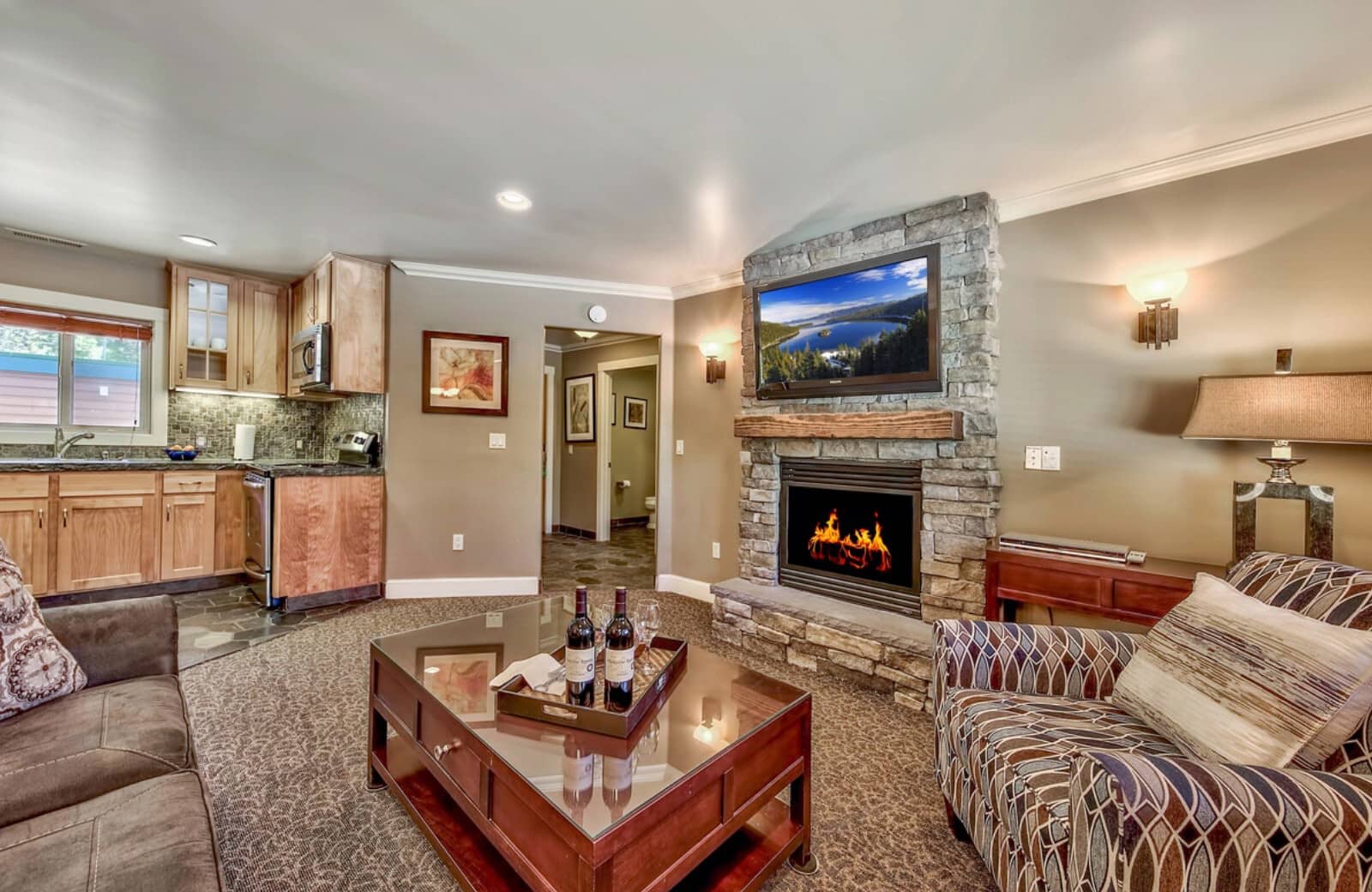 Living area with stone gas fireplace and adjacent kitchenette