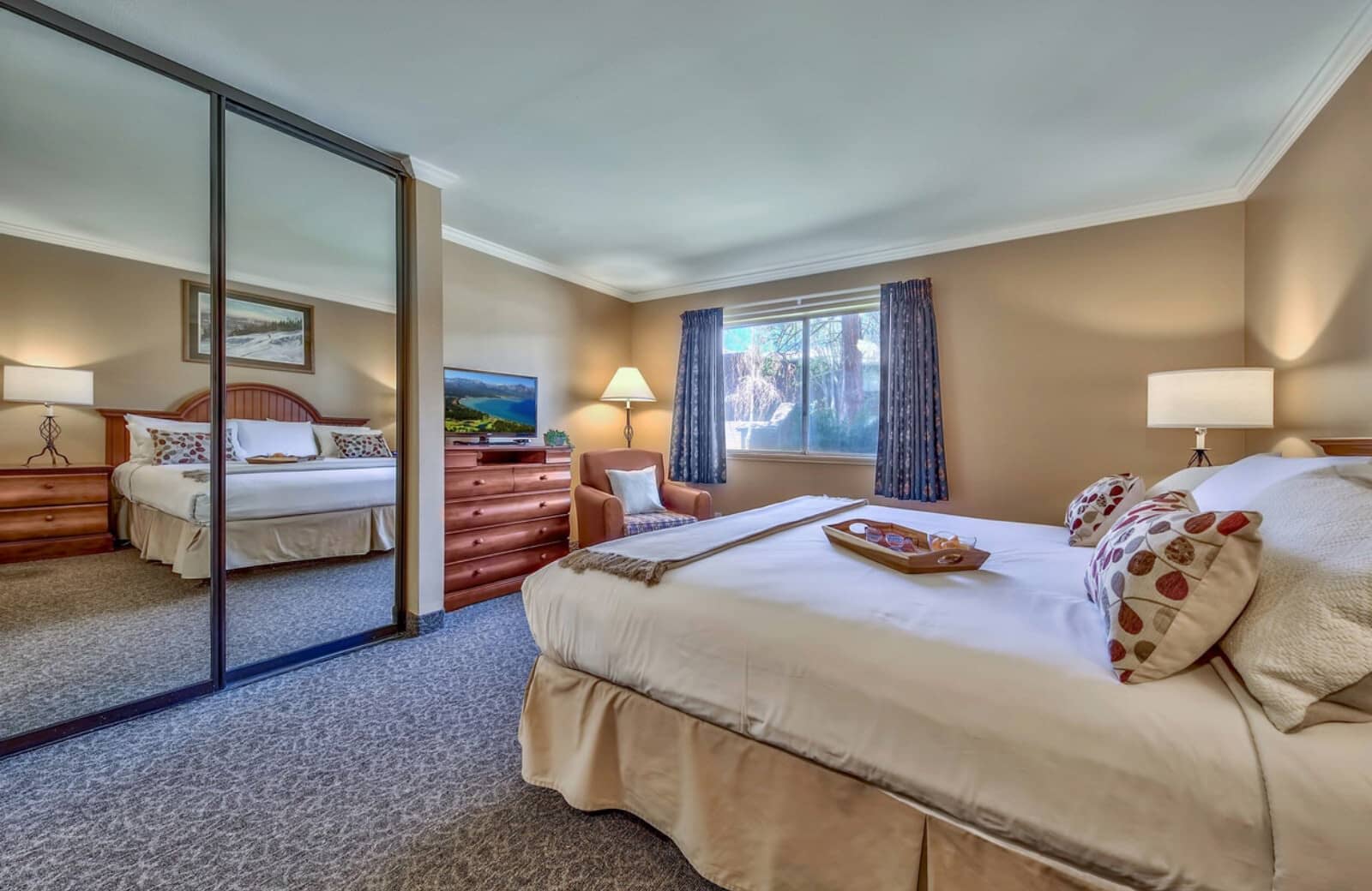 Bedroom with king bed and floor-to-ceiling mirrored closets