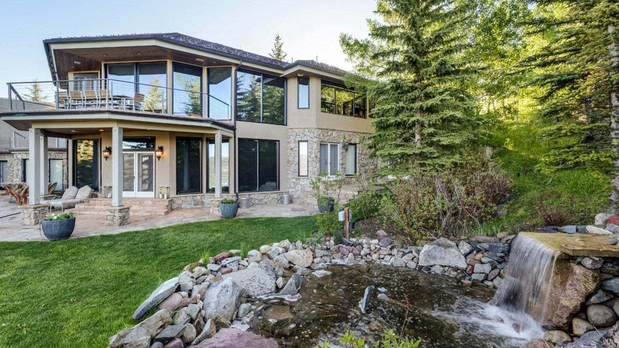 Backyard with stone patio and tiered rock waterfall feature