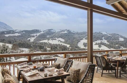 Covered dining terrace with seating for 8 and ski run views