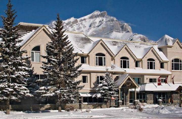 Building exterior with snow-covered roof and mountain peak backdrop