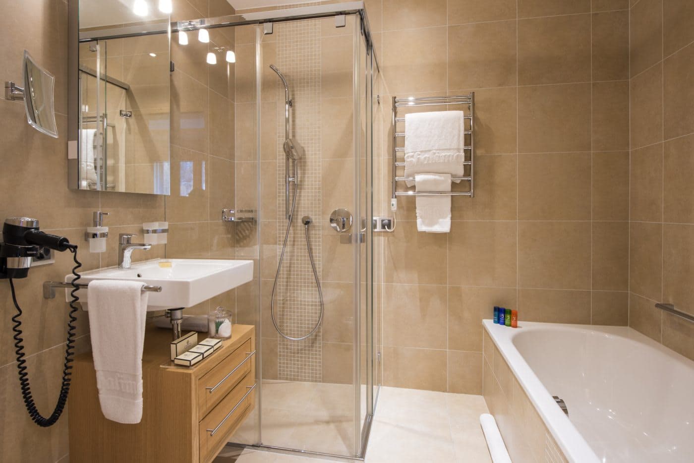 Bathroom with walk-in glass shower, separate bathtub, and heated towel rack