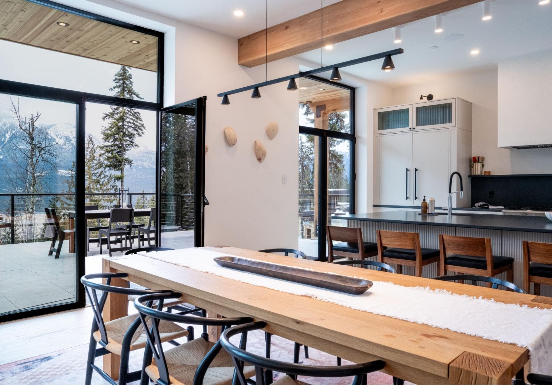 Open-plan dining area and kitchen with island seating and deck access