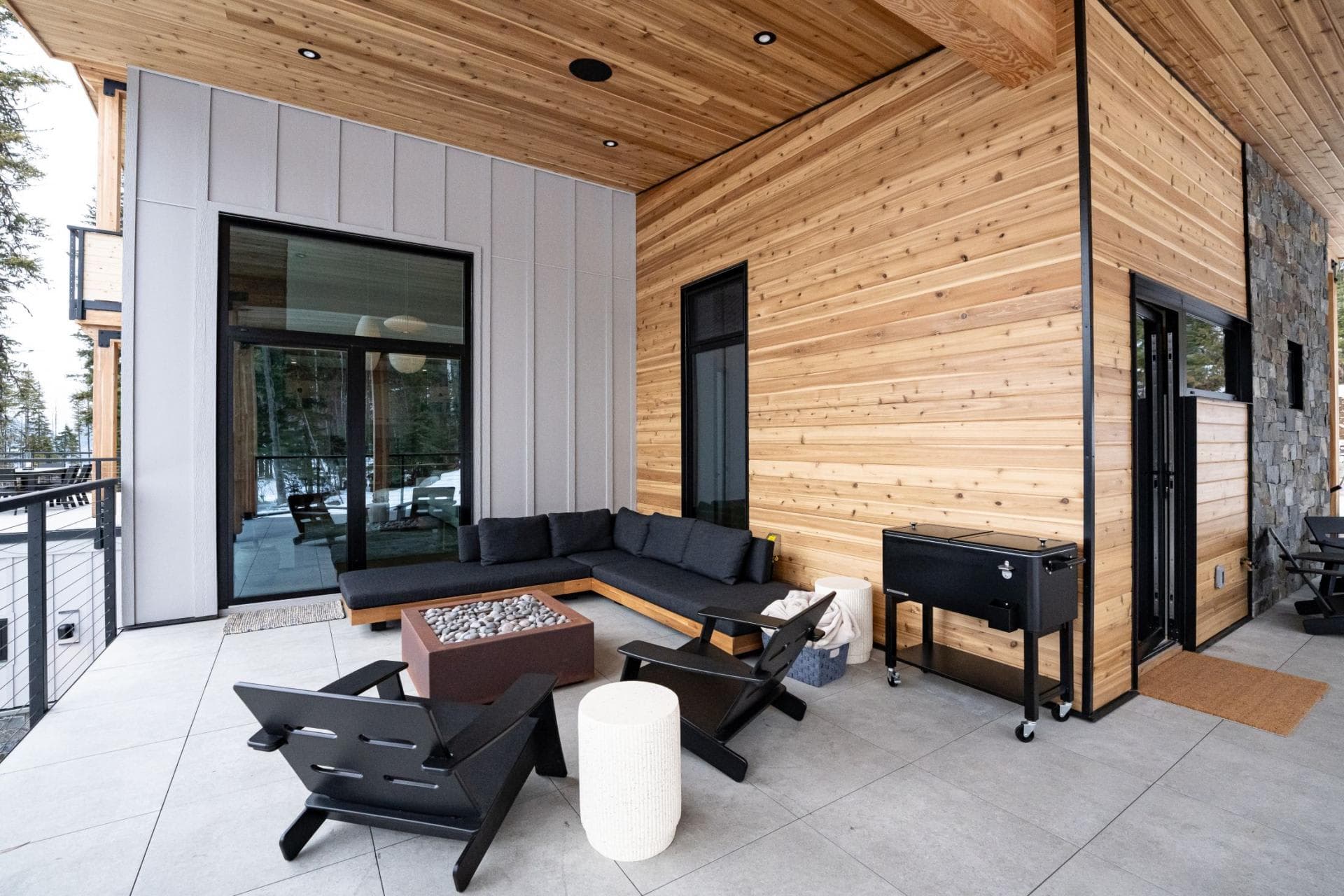 Covered patio with gas fire pit, sectional seating, and rolling cooler