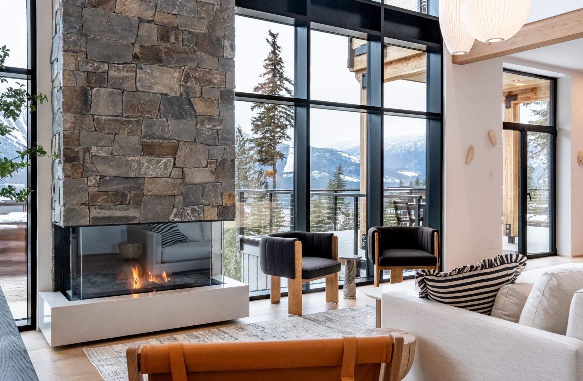 Living area with floor-to-ceiling windows and wood-burning stone fireplace