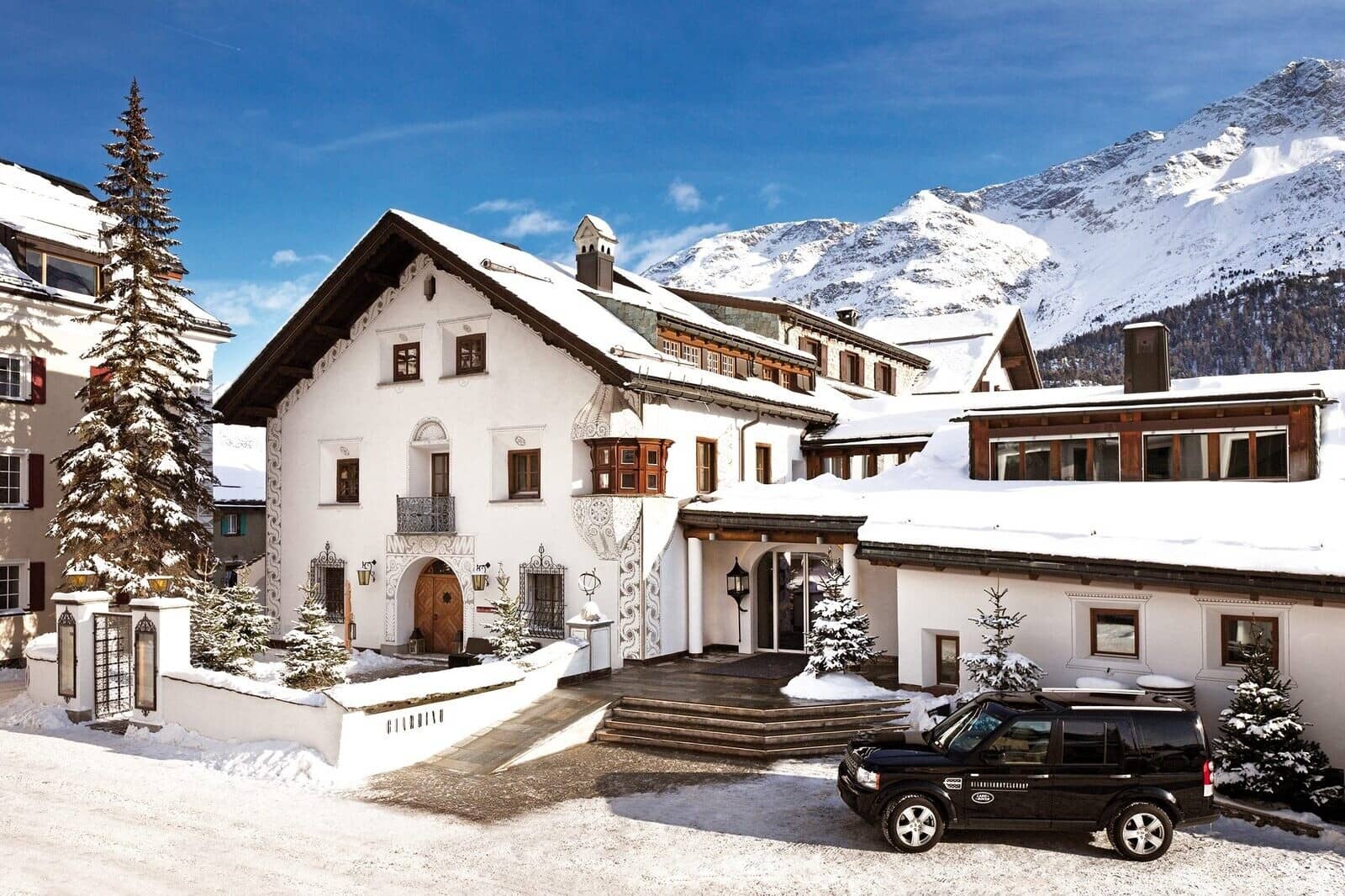 Chalet entrance with traditional sgraffito masonry and mountain backdrop