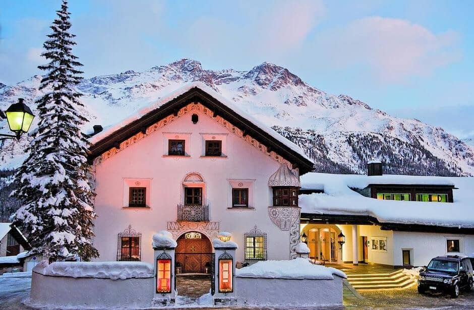 Chalet exterior with traditional sgraffito wall art and mountain backdrop