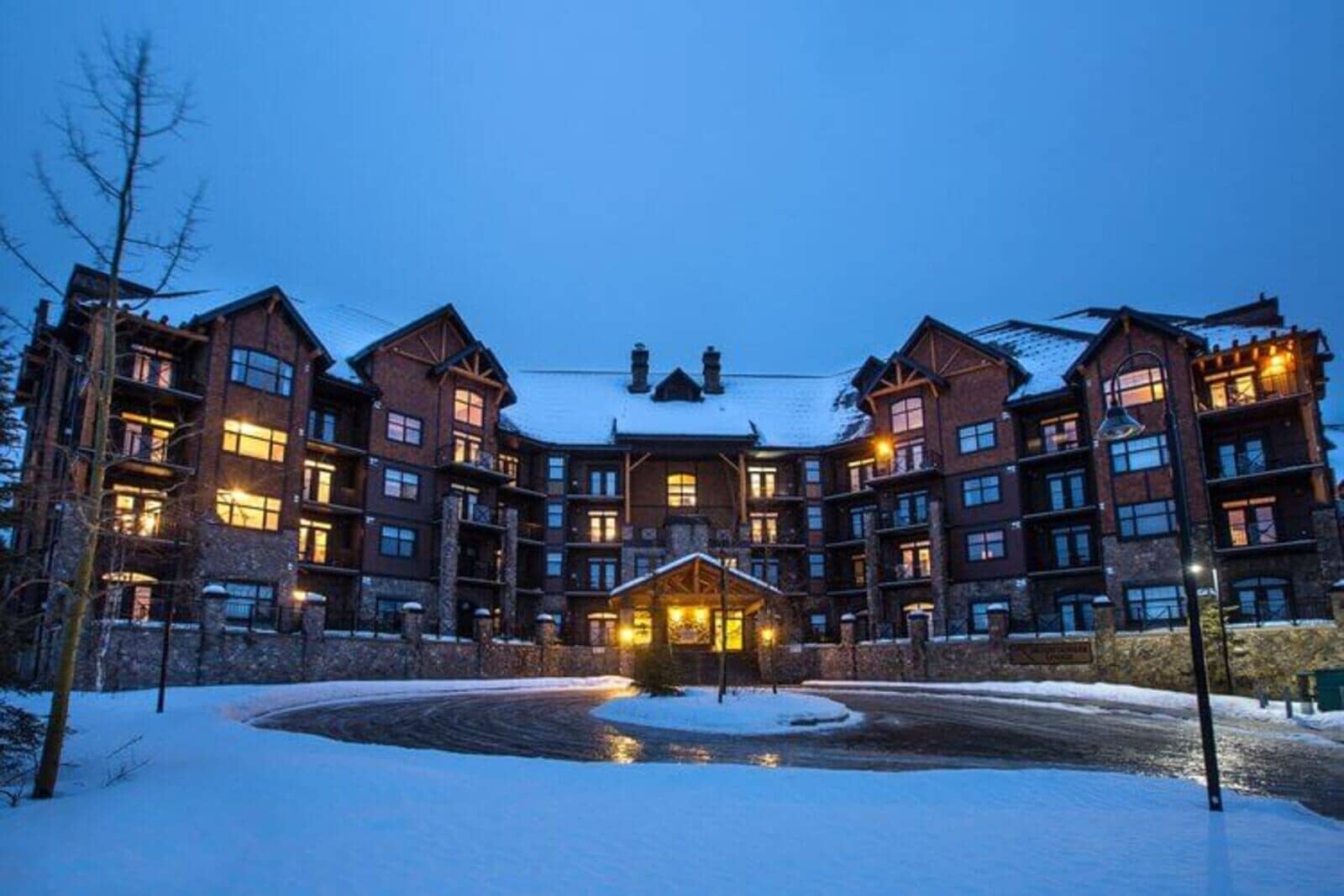 Ski-in, ski-out lodge exterior featuring circular driveway and covered entrance