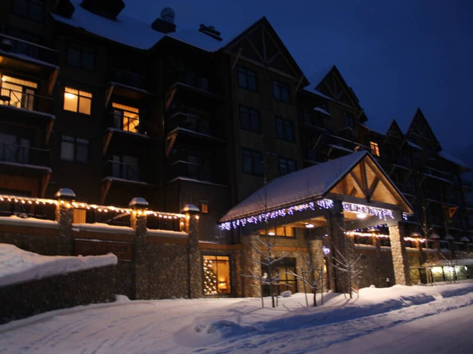 Ski-in lodge entrance with covered porte-cochère and heated driveway