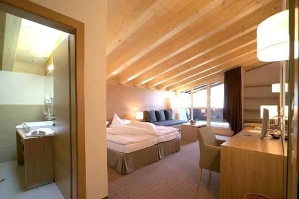 Primary bedroom with king bed, vaulted wood ceiling, and ensuite access