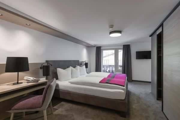 Bedroom with king bed, desk workspace, and balcony access