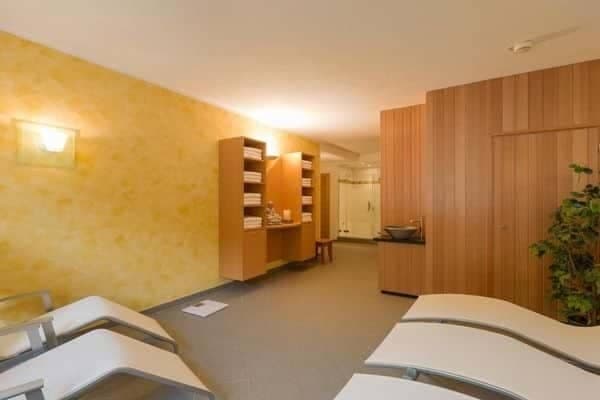 Spa relaxation room with loungers and wood-paneled sauna access
