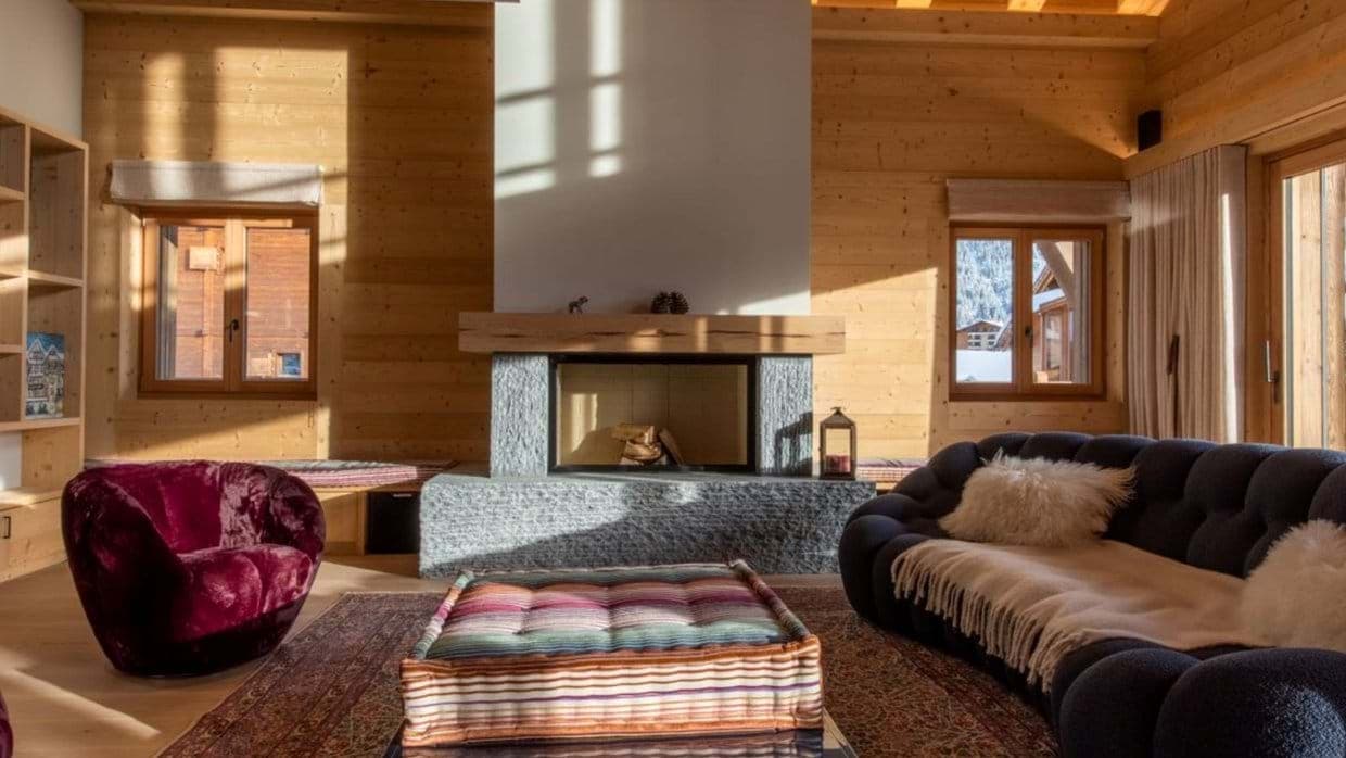 Living area with wood-burning fireplace and mountain-view window benches