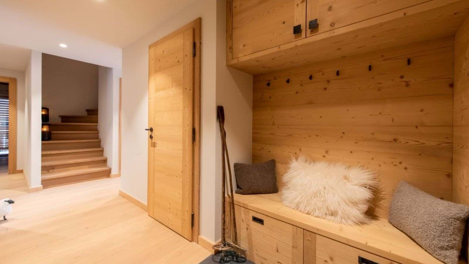 Entryway mudroom with bench seating, gear hooks, and overhead storage