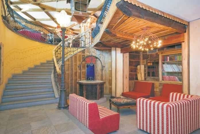 Stone entryway with curved staircase, reading nook, and integrated bookshelves