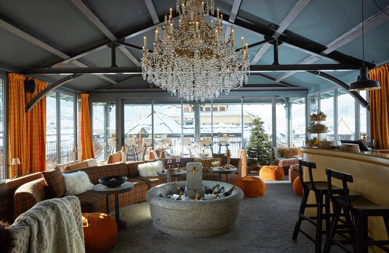 Glass-walled lounge featuring stone beverage chiller and village views