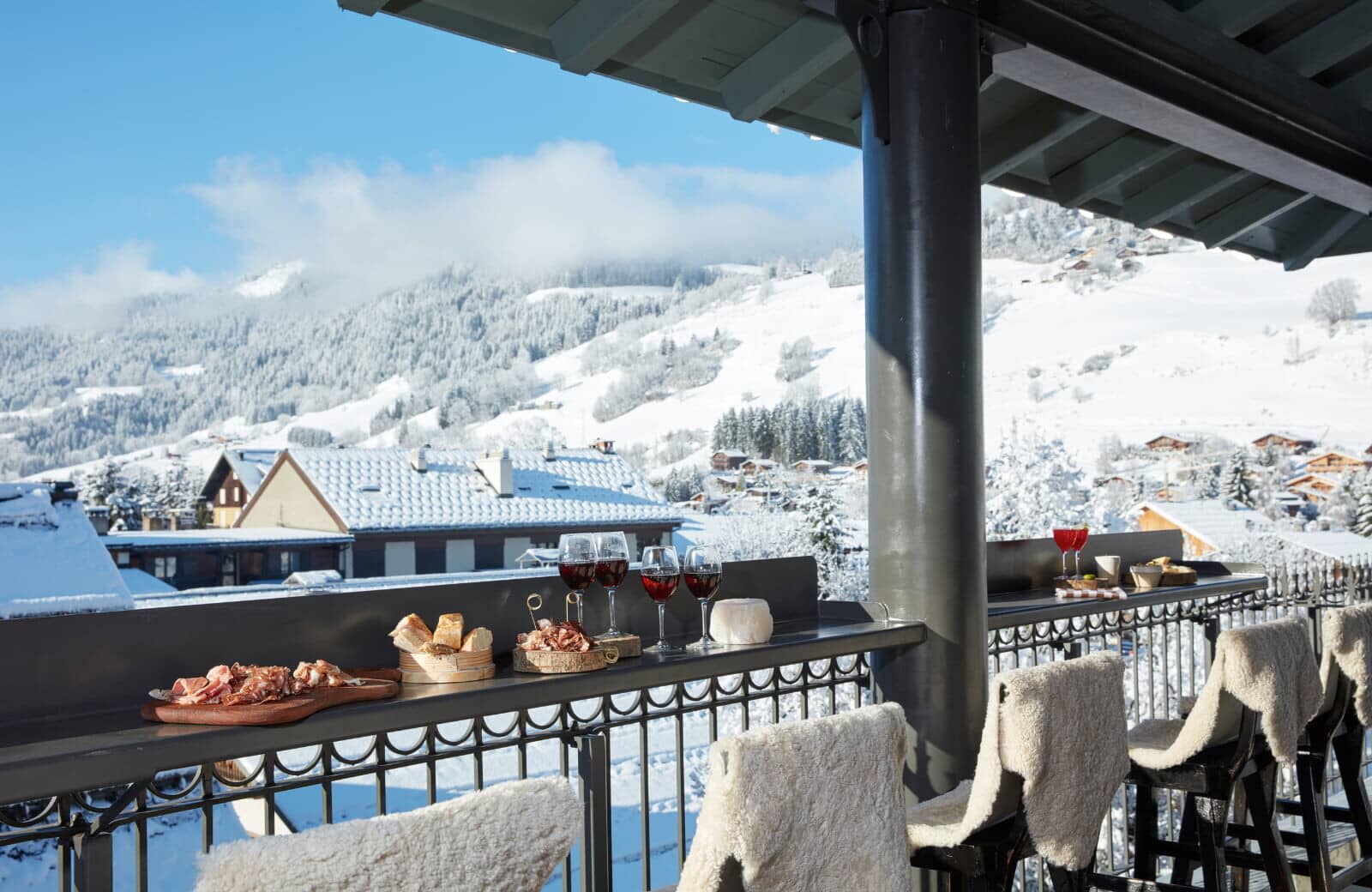 Covered balcony bar with sheepskin seating and mountain views
