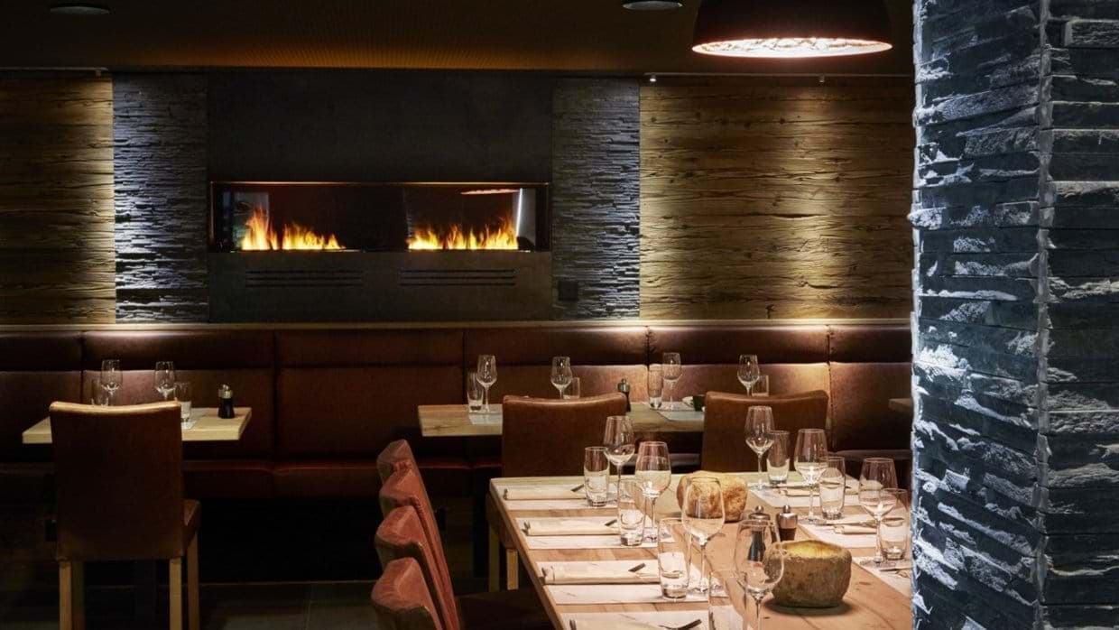 Dining room with linear gas fireplace and leather banquet seating