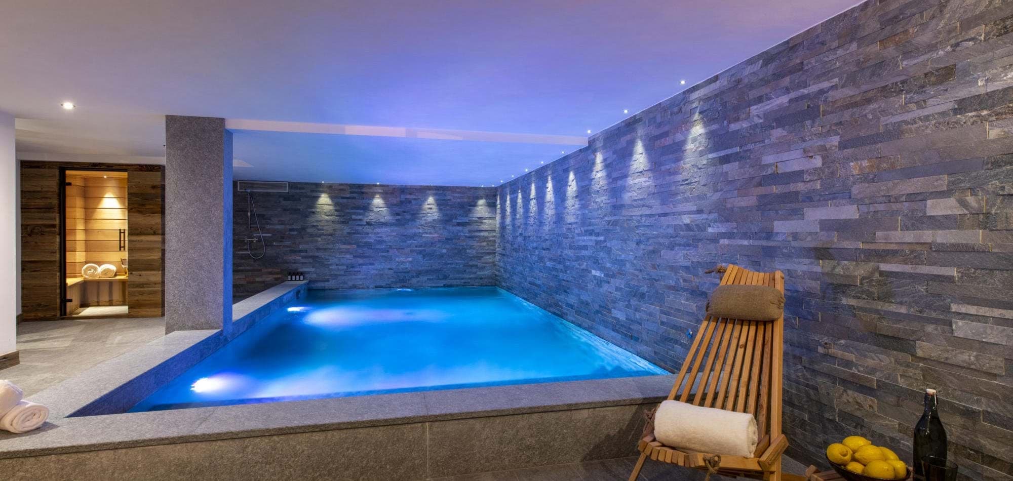 Indoor pool and stone spa with adjoining cedar sauna