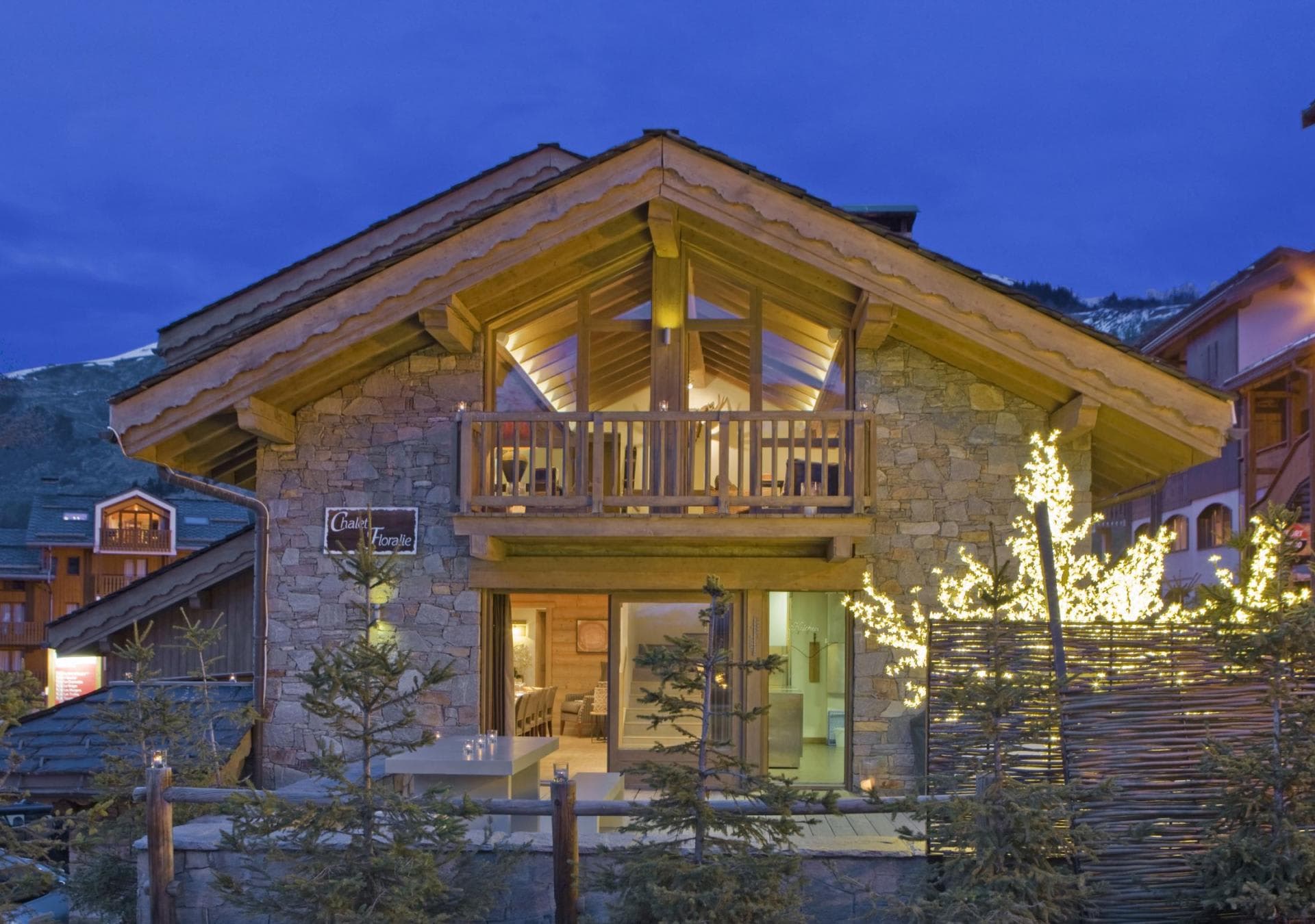 Stone and timber chalet with upper balcony and outdoor terrace seating