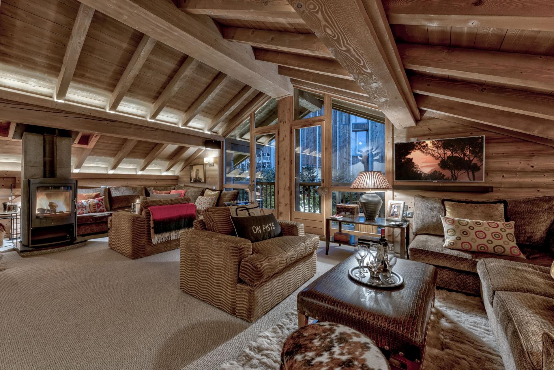 Top-floor living area with wood-burning stove and vaulted timber ceilings