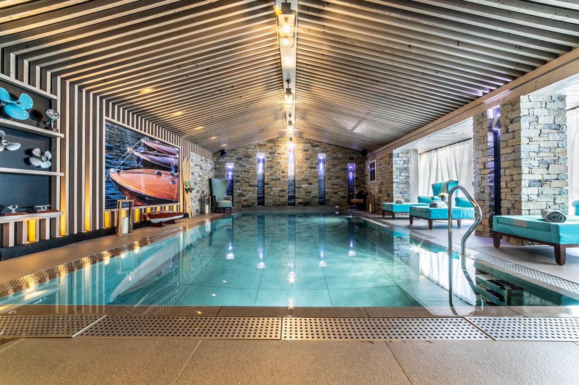 Indoor heated pool with poolside loungers and vaulted wood ceiling