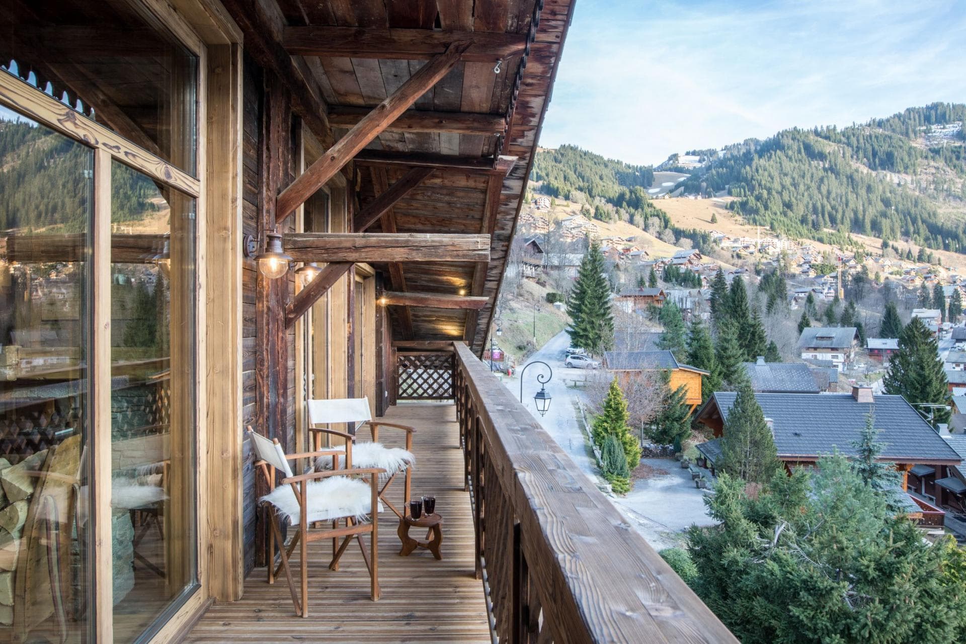Covered timber balcony with seating and village valley views