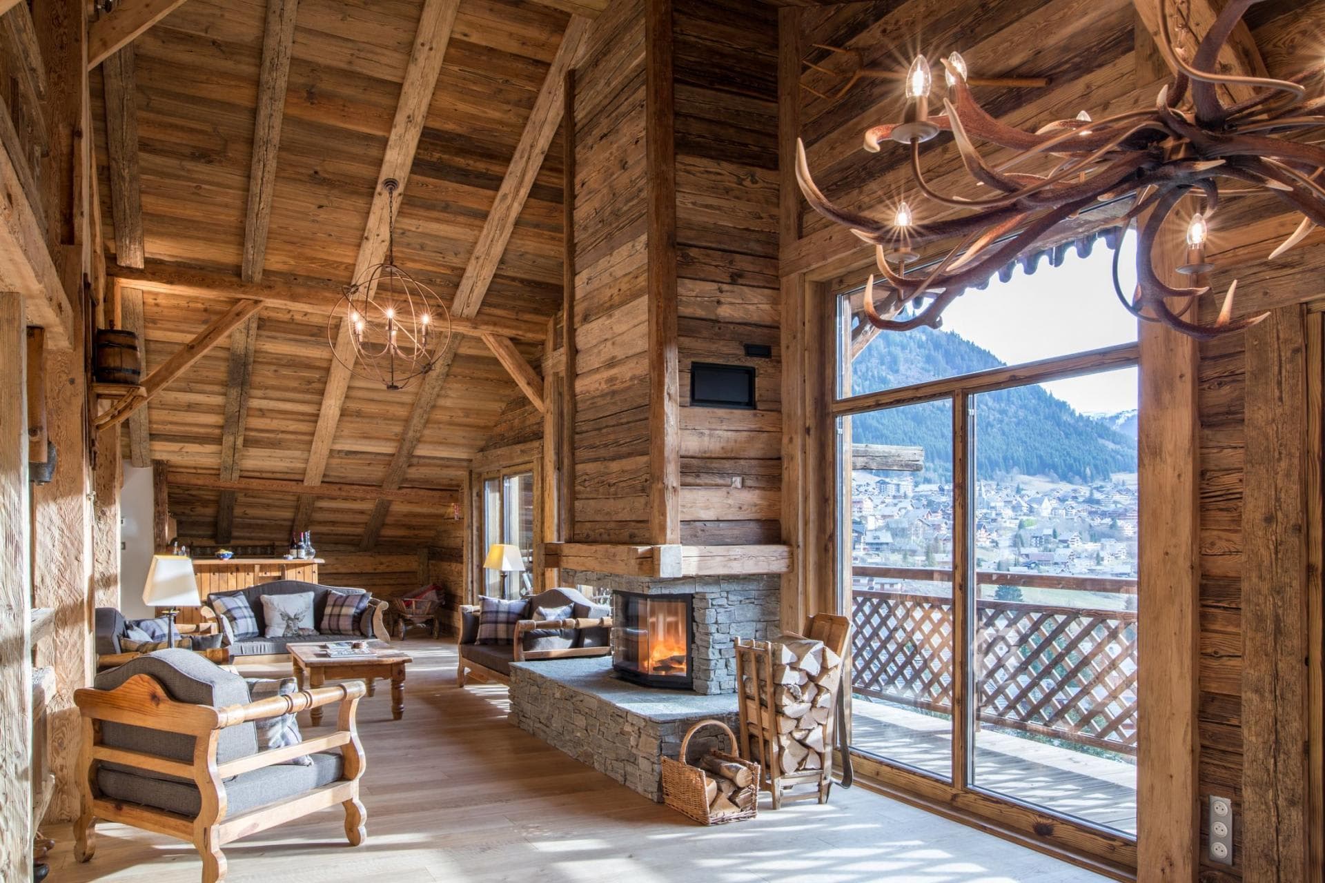 Living area with stone fireplace and mountain-view balcony