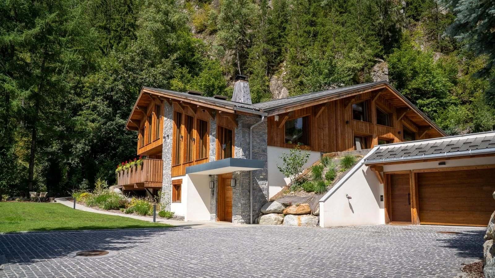 Mountain chalet exterior with timber siding and attached private garage