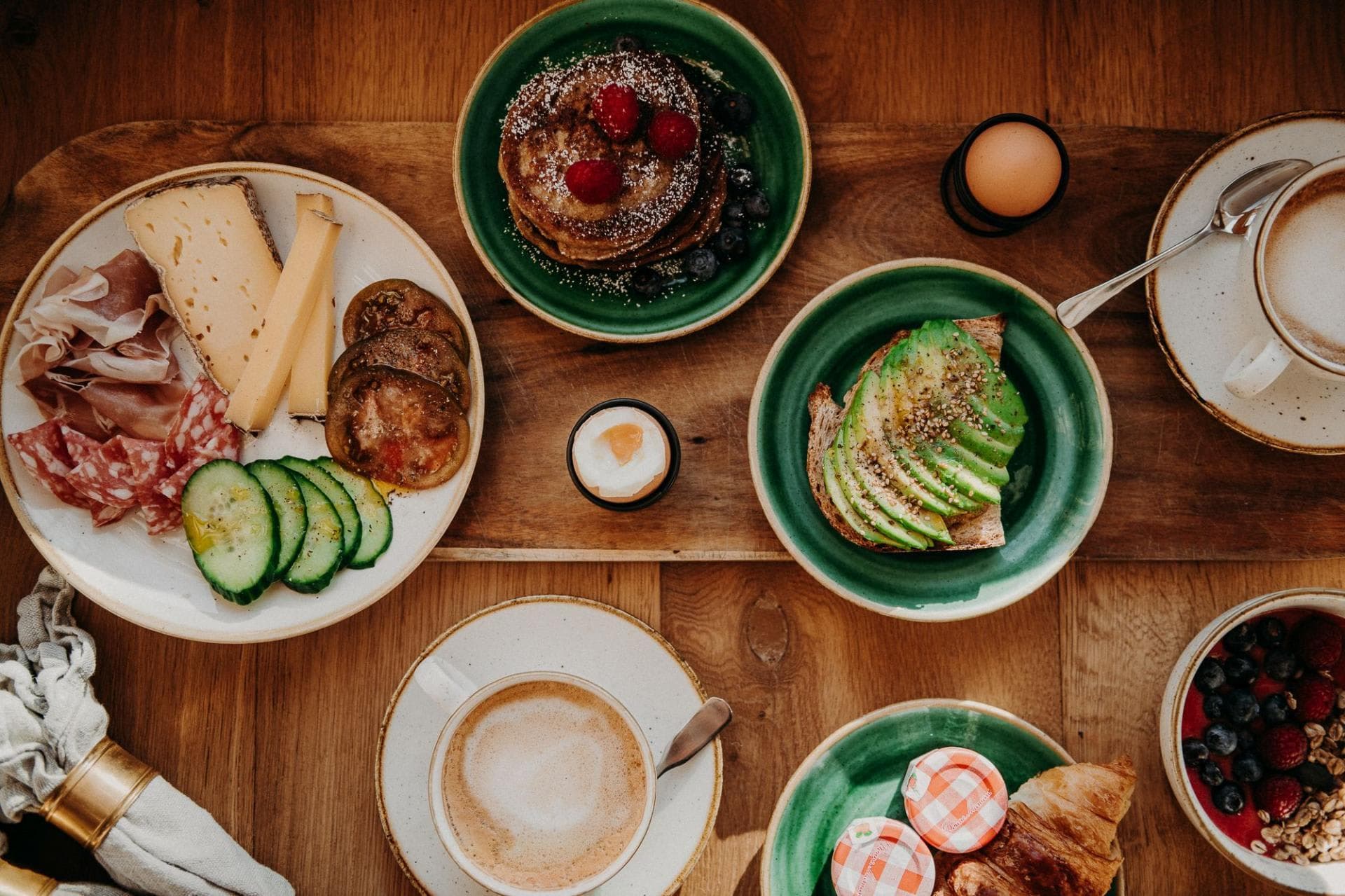 Breakfast spread featuring pancakes, avocado toast, and coffee service