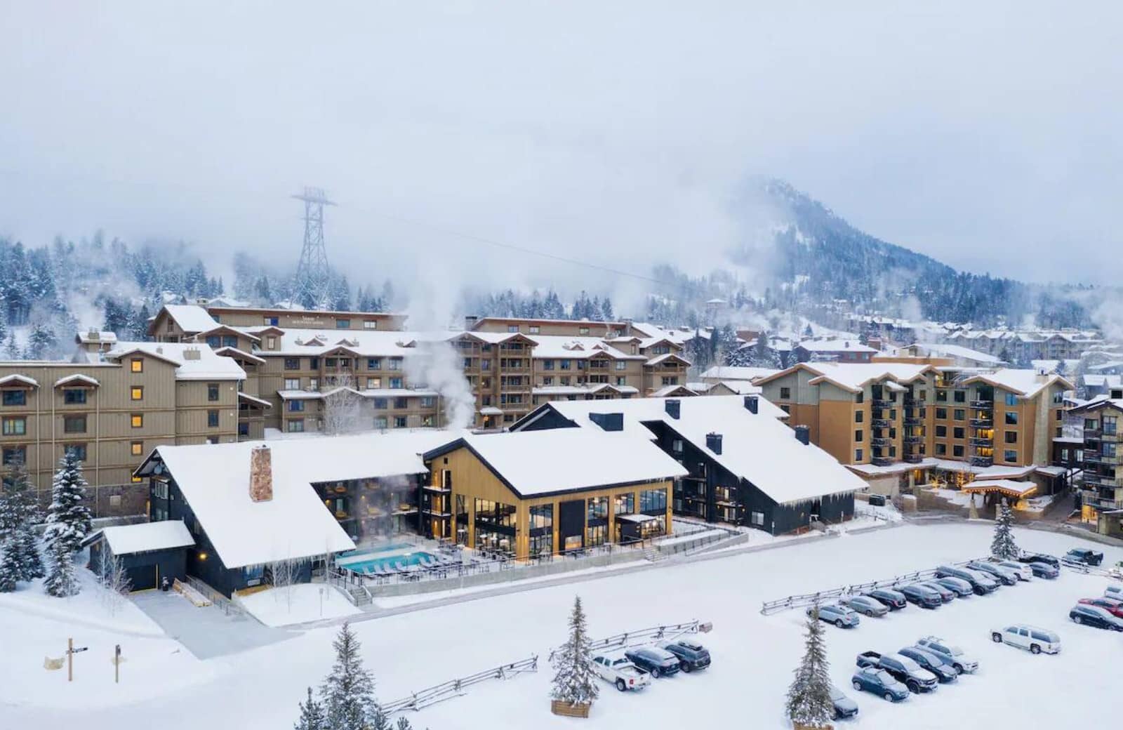 Ski-in/ski-out resort exterior with heated outdoor pool and mountain backdrop