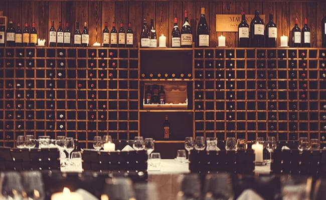 Wine cellar dining room with floor-to-ceiling racks and candlelit table