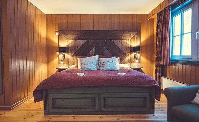 Primary bedroom with king bed and reading lamps; wood-paneled walls