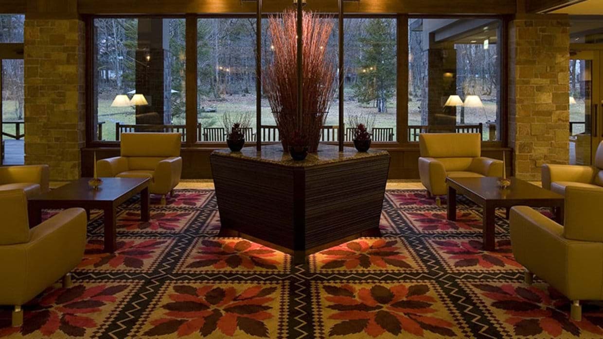 Lobby lounge with club chairs and floor-to-ceiling forest views