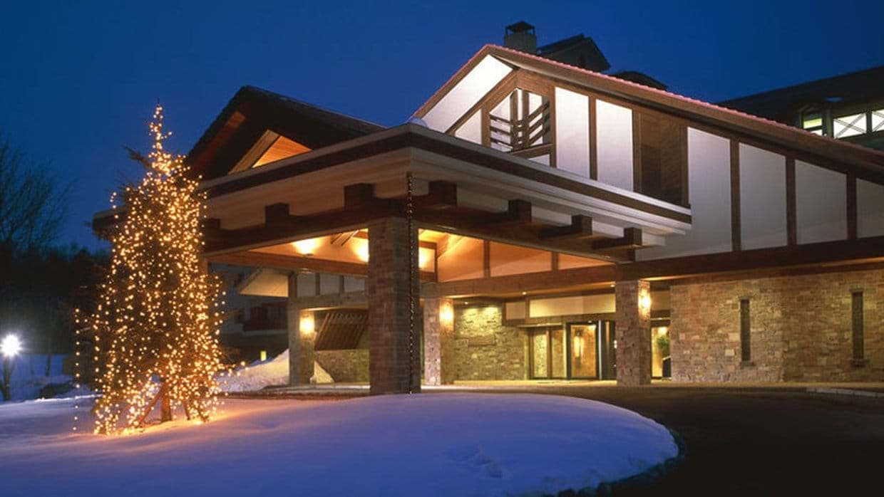 Porte-cochère entrance with stone pillars and covered guest drop-off