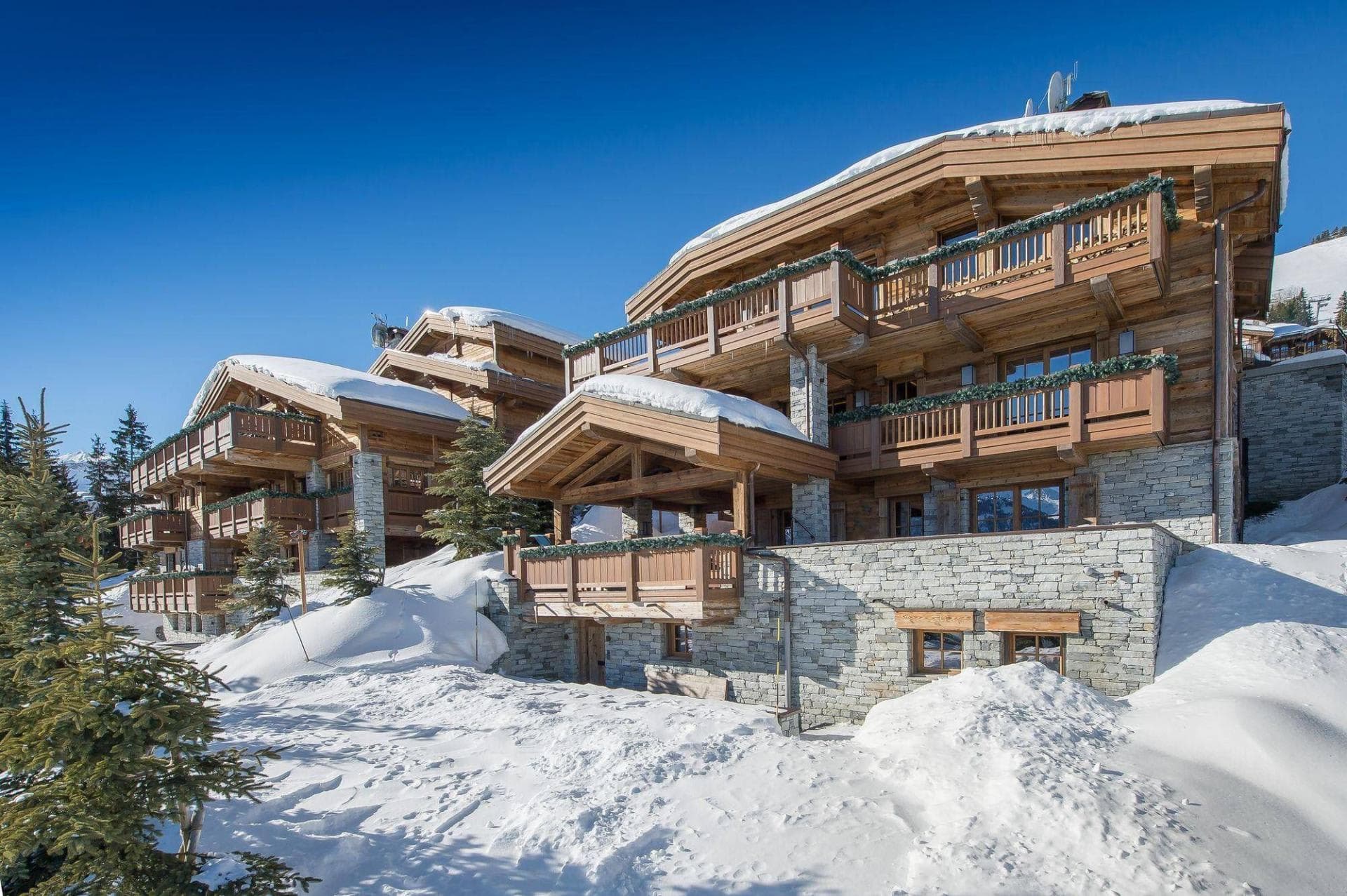 Ski-in, ski-out timber chalets with private balconies and stone masonry