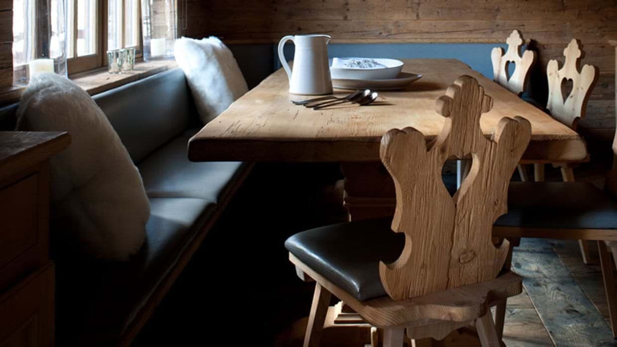 Dining area with built-in banquet seating and carved wooden chairs