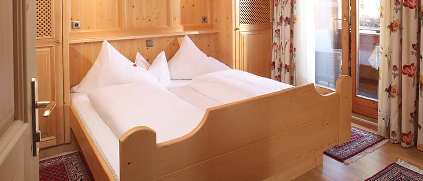 Bedroom with wood-framed king bed and private balcony access