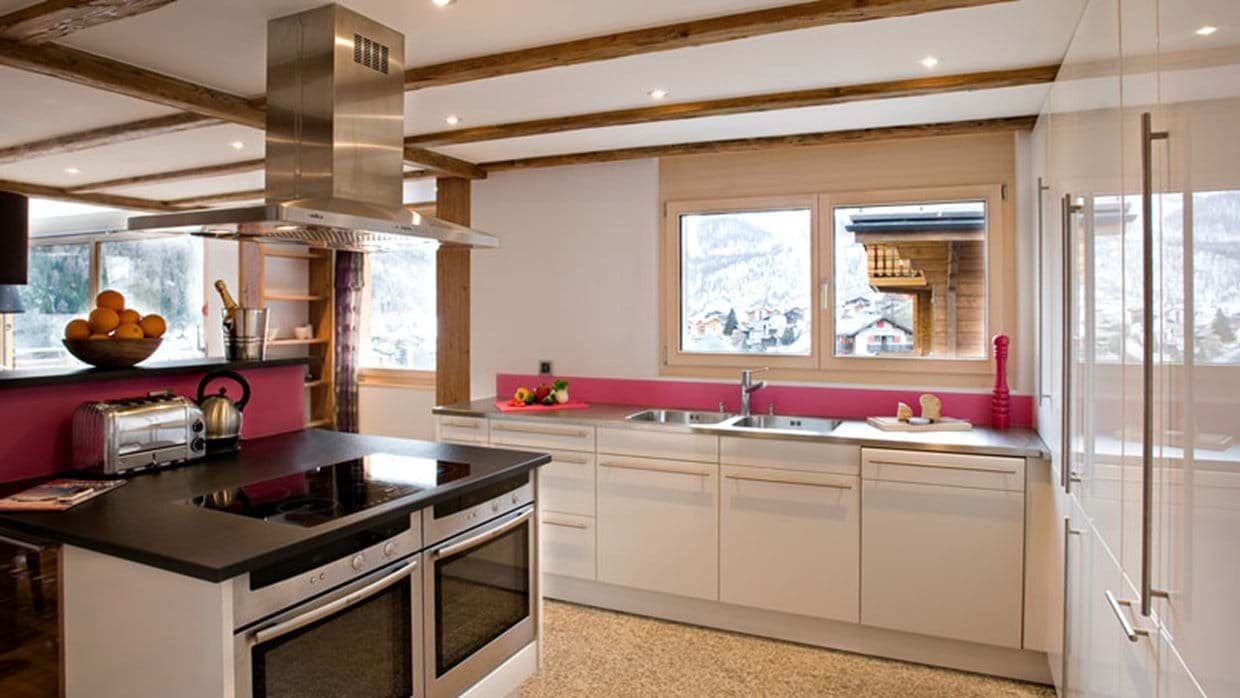 Kitchen with dual ovens, induction cooktop, and alpine village views