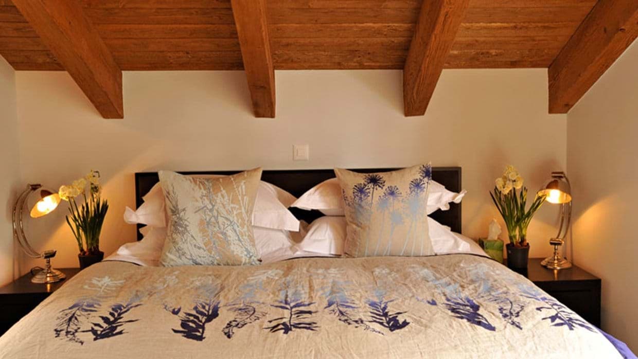 Attic bedroom with king bed and original exposed timber beams