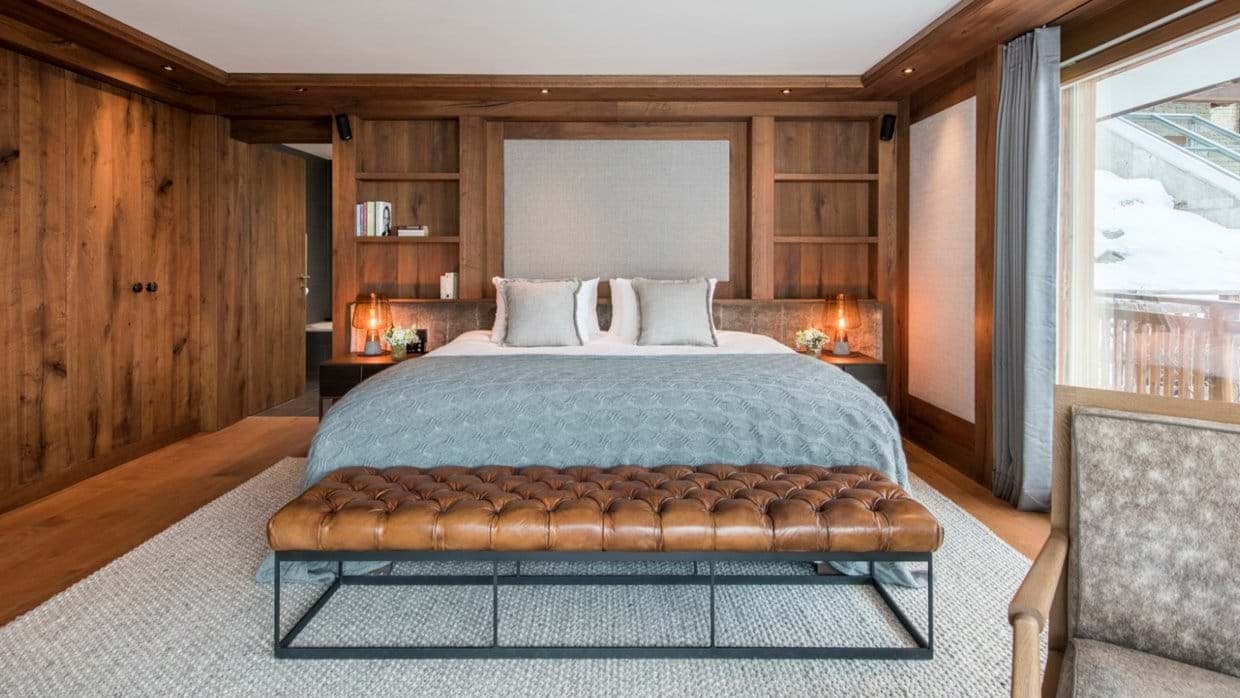 Primary bedroom with king bed and wood-paneled storage walls