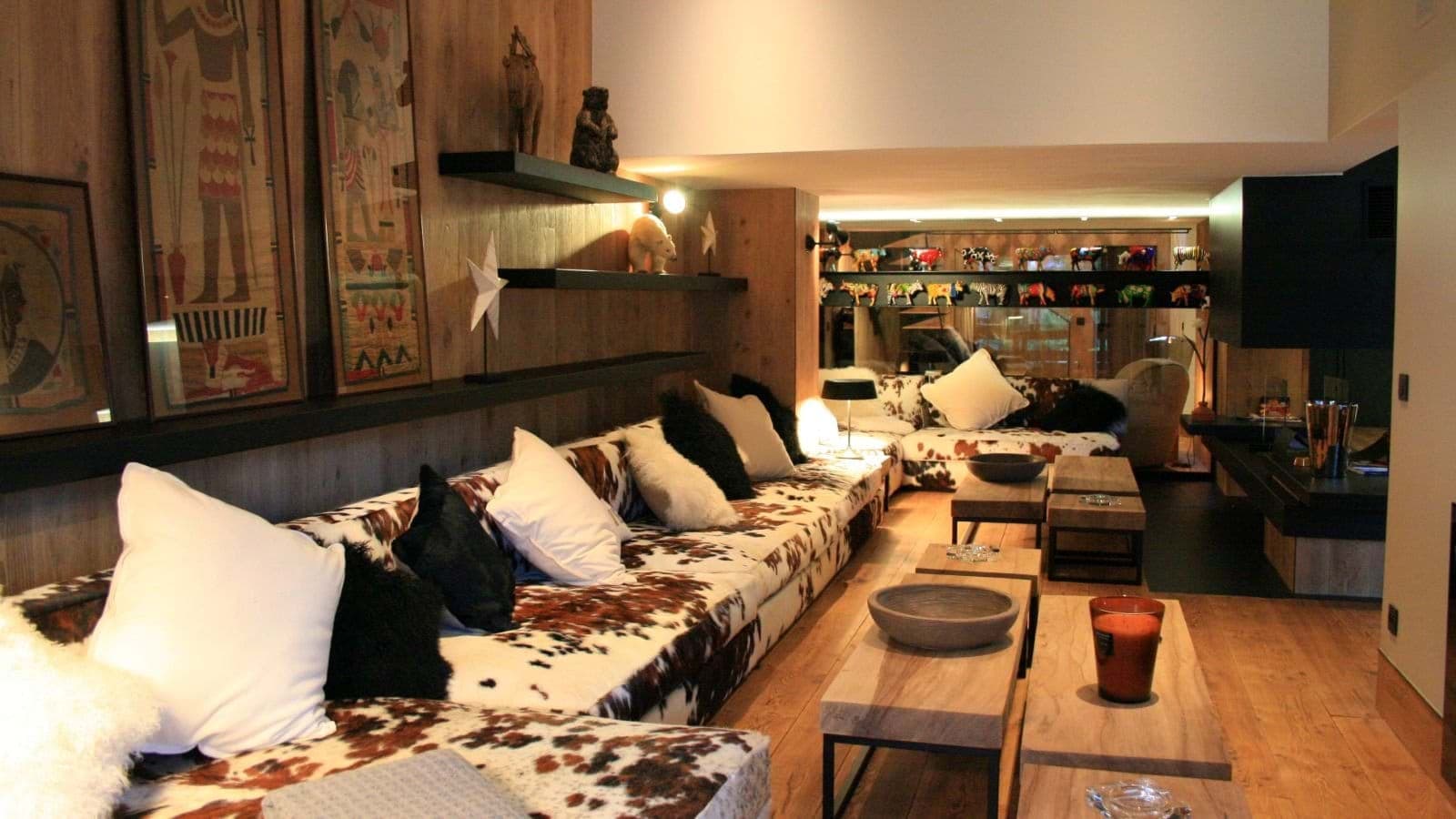 Lower level lounge with cowhide sectional and wood-burning fireplace