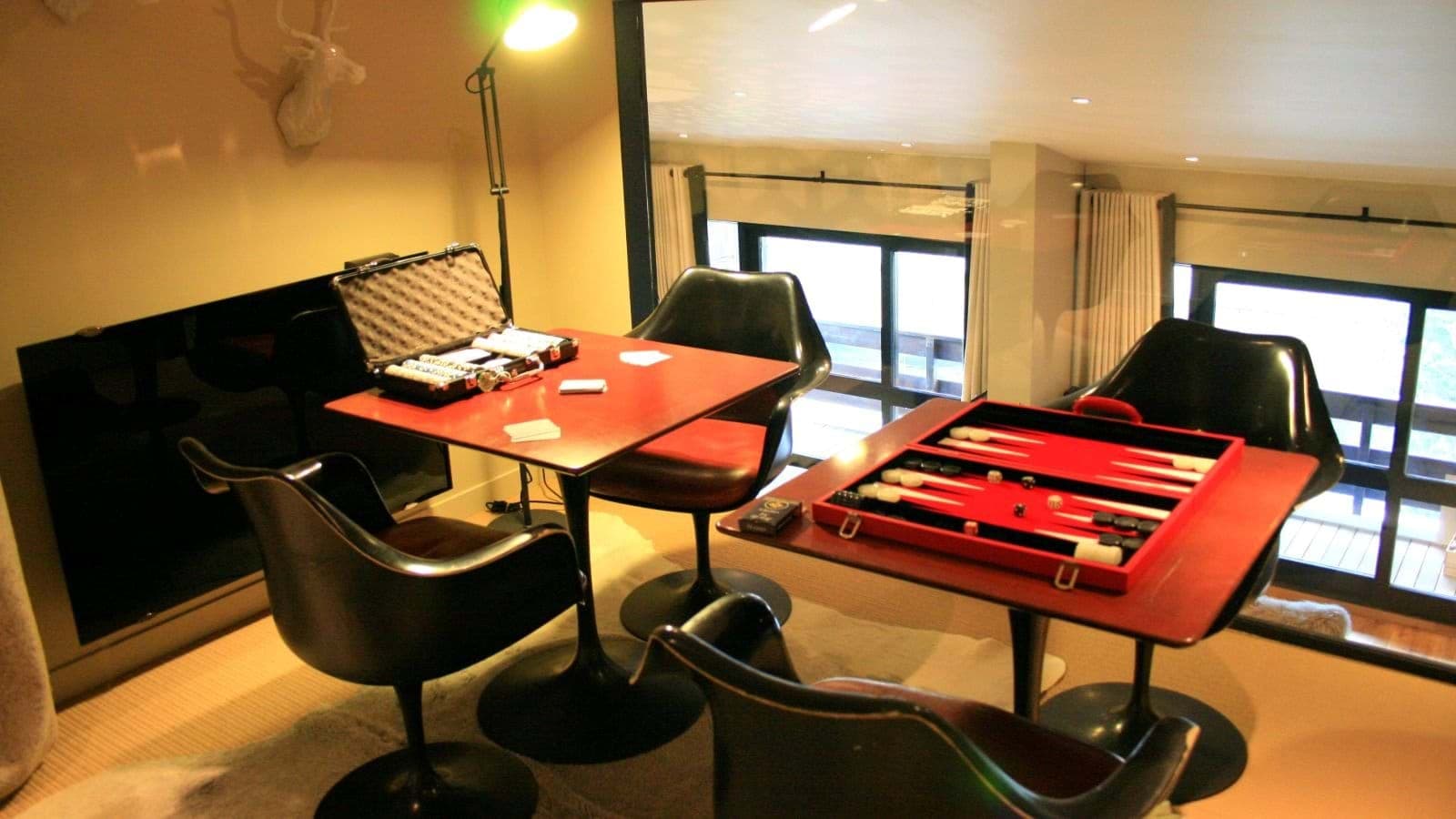 Mezzanine game area with poker set, backgammon table, and tulip chairs