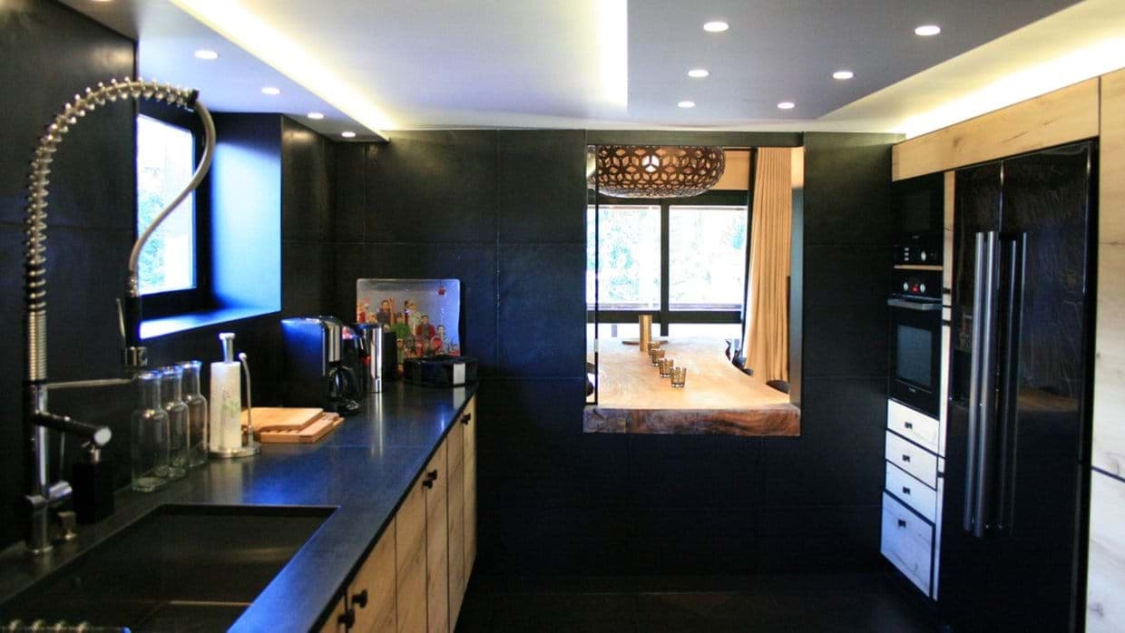 Kitchen with high-pressure faucet and pass-through window to dining table
